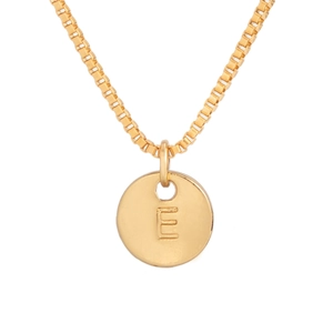 Macro shot of gold box chain and round pendant with engraved letter E detail