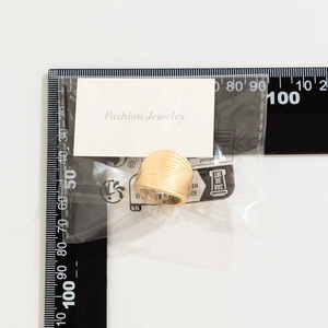 Top view of a gold wide pleated ring with textured finish next to a measuring ruler