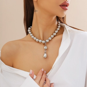 Collana girocollo a perle argentate con grande ciondolo a goccia d'acqua su una modella