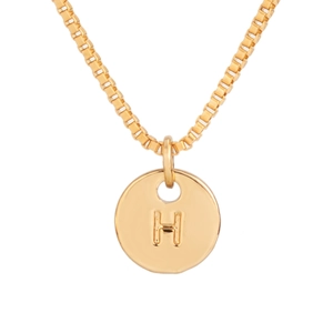 Detail of gold box chain necklace with a polished round pendant featuring letter H