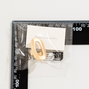 Matte gold oval ring with floral textured metal finish shown with size measurement ruler