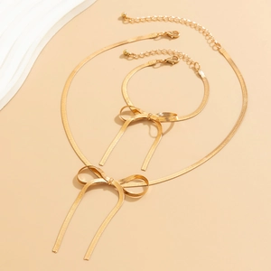 Flachbild von goldenen Schlangenkette Halskette und Armband Set mit Schleifendetails