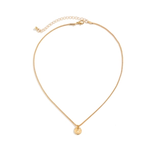 Detailed macro view of golden box chain with letter K engraved round pendant