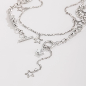 Detail of silver layered star necklace featuring toggle clasp and polished metal beads