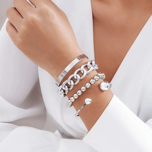 Détail d'un ensemble de 4 bracelets en métal argenté avec chaînes et joncs polis