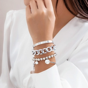 Ensemble de bracelets argentés avec perles et chaîne porté au poignet par le mannequin