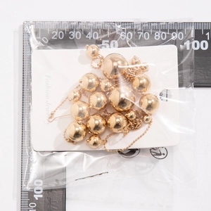 Mesure détaillée des boucles d'oreilles à pampilles dorées sur une règle de précision
