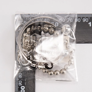 Détail du bracelet à perles argentées et jonc métallique de 65mm avec échelle de mesure