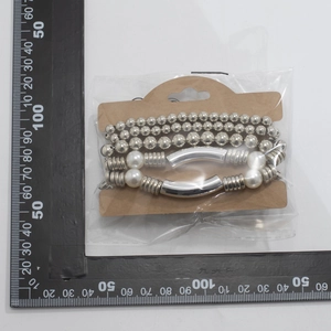 Détail d'un ensemble de 4 bracelets à billes argentées et perles sur carton