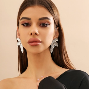 Minimalistische zilveren metalen blad oorknopjes met textuur gedragen door model