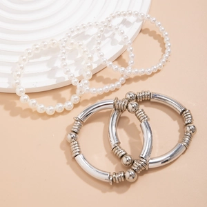 Détail de bracelets en perles fantaisie et joncs métalliques argentés en set