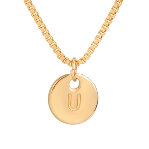 Macro shot of gold-plated round pendant with engraved letter U on a fine box chain
