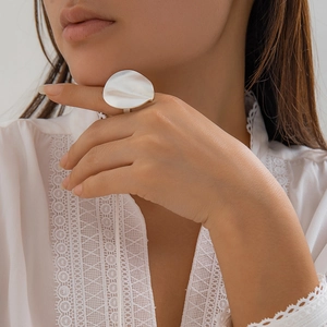 Minimalist silver irregular disk ring with hammered texture on a model's hand