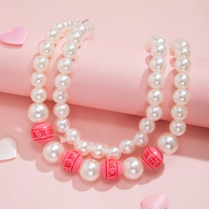 Detail einer zweilagigen Perlenkette mit rosa OX-Perlen auf einem Dekoständer