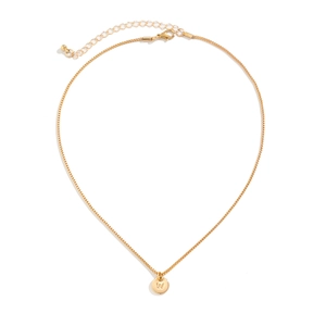 Detailed shot of golden round pendant with engraved W letter on a sleek box chain