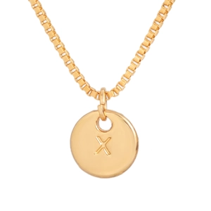 Detail of gold box chain necklace featuring a polished round pendant with engraved letter X