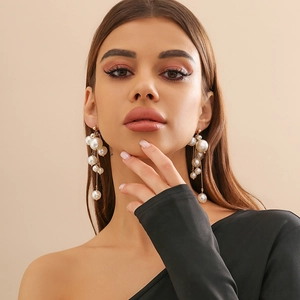 Élégantes boucles d'oreilles grappe de perles blanches et accents dorés sur mannequin