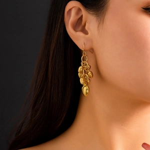 Detailopname van gouden gelaagde druppeloorbellen met hartjes bij een model