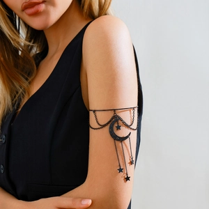 Λεπτομερής λήψη μαύρου γοτθικού περιβραχιόνιου με φεγγάρι και αλυσίδες με αστέρια