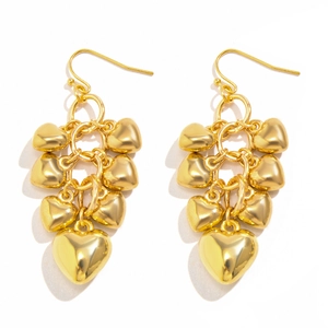 Detailopname van gouden hartjes oorbellen met gelaagde hangers in clusterstijl
