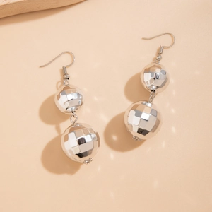 Macro shot of silver geometric drop earrings featuring multi-faceted disco ball beads