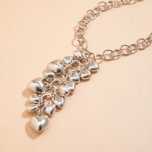Zilveren hartjeshanger choker halsketting met grove schakelketting op beige achtergrond