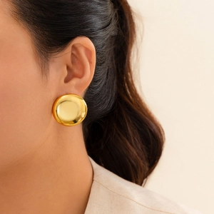 Polished gold dome earrings on ear showing metallic luster and geometric minimalist style