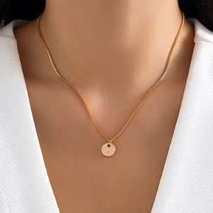 Gold letter L necklace with round pendant and box chain worn on model neck