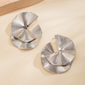 Detailed macro view of silver earrings featuring a double-layered pleated fan design