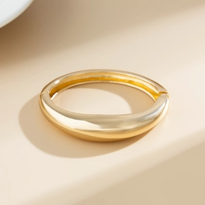 Dettaglio del bracciale a goccia in oro massiccio con finitura a specchio lucida e curva