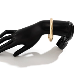 Dettaglio del bracciale rigido dorato lucido a specchio con chiusura a cerniera laterale