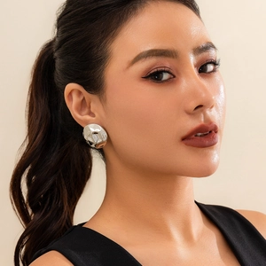 Close-up of metallic irregular silver earrings with liquid lava texture on model