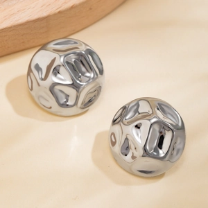 Detail of silver drop earrings featuring irregular hammered texture and fluid metal finish