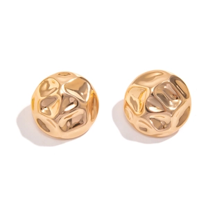 Detail of gold metal stud earrings with textured hammer finish and spherical shape