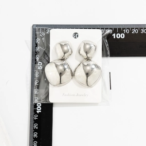 Detail view showing polished silver geometric square earrings with mirror finish and 50mm size scale