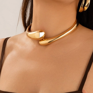 Dettaglio della collana choker in metallo liquido dorato e orecchini a specchio