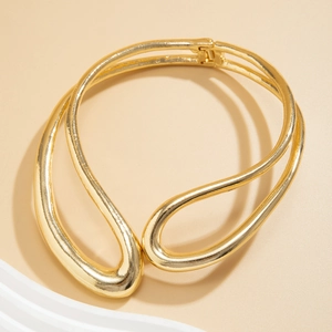 Détail du collier ras du cou doré aux lignes organiques avec fermeture à charnière robuste