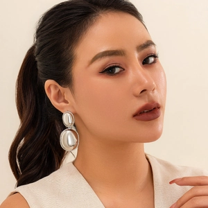 Close-up of geometric double oval drop earrings with silver finish and pavé stones