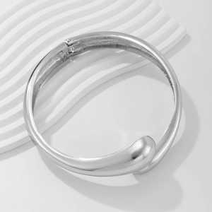 Dettaglio del bracciale a goccia d'argento lucido con finitura metallica a specchio
