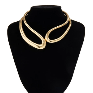 Gros plan d'un large collier ras du cou doré au design organique métallique irrégulier