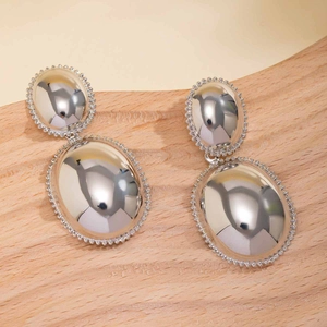 Macro shot of silver large oval drop earrings with mirror polished finish and beaded edges