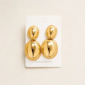Detail view of large gold oval double-layer earrings with bead edge on fashion jewelry card