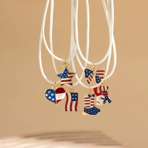 Dettaglio dei ciondoli smaltati bandiera USA con charms a cuore e stella su collana a corda