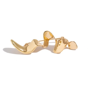 Primer plano de broche dorado con diseño de ondas de metal líquido y acabado pulido espejo