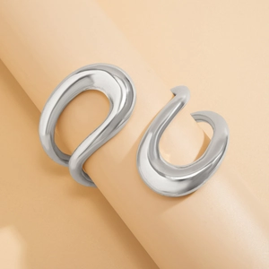Gros plan de boucles d'oreilles argentées incurvées avec finition métal liquide poli