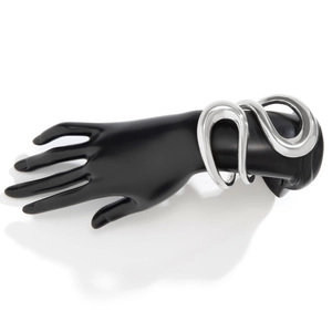 Bracelet jonc argenté poli au design organique fluide sur un modèle de main noire