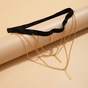 Detail of multi-layer gold leg chain with geometric bars and black elastic band