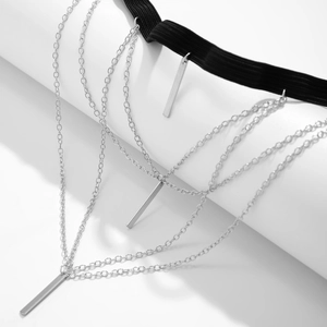 Detail of multi-layered silver star leg chain with metallic fringe and black elastic band