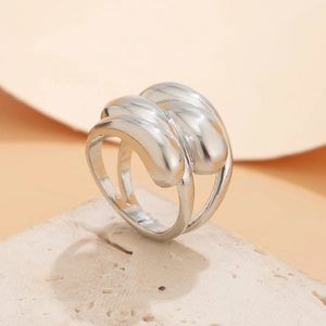 Vue détaillée d'une bague en métal argenté poli au design géométrique 3D multicouche