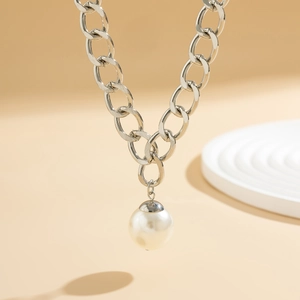 Detailed close-up of a large polished silver link chain necklace with a pearl pendant